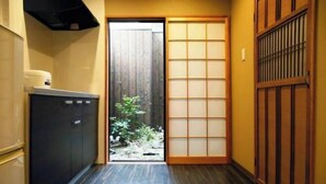A narrow hallway with a sliding door leading to a small garden area. - Kyokoi Toujimikuni (Kyoto)