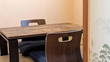 A wooden dining table with chairs, a bench, and a wall with a nature-themed mural.