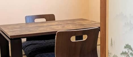 A dining table with chairs, a bench, and a wall with a mural.
