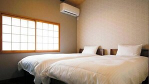 A room with a large bed, a window, and an air conditioning unit. - Kyokoi Toujimikuni (Kyoto)