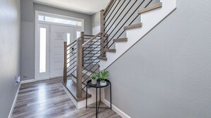 A staircase with wooden steps and metal railings, leading to a door with a window. - 5BR/5BA Arlington Getaway w/ Private Hot Tub Close to UTA & AT&T (Arlington)