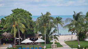 Eine Strandbar mit Außenbereich, Sitzgelegenheiten, Palmen und Meerblick.