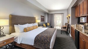 A hotel room with a bed, bedside table, lamp, and a kitchenette with a microwave and toaster. - Napa Valley | Napa Wine Getaway | Pool & Hot Tub (Napa)