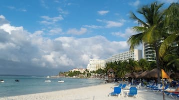 Playa privada, arena blanca, sillas reclinables de playa, sombrillas