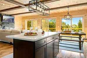 Una cocina amplia con una isla grande, armarios de madera y una chimenea de piedra.