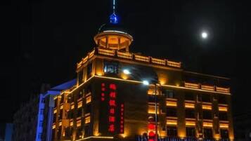 A multi-story building with illuminated signage and a prominent tower structure.