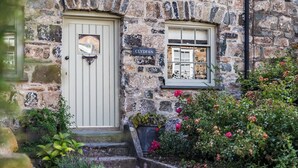 A stone building with a light-colored door and a window with a nameplate reading "CLYDFAN". - A character cottage with a contemporary glass extension, in the heart of Newport (Newport)
