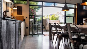 A modern kitchen with a dining area, large windows, and a view of the outdoors. - A character cottage with a contemporary glass extension, in the heart of Newport (Newport)