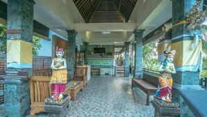 A temple interior with statues, a tiled floor, and a central altar. - Adi Bisma Inn by Mahaputra (Bali)