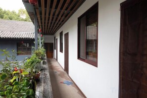A corridor with a tiled roof, potted plants, and a wooden door. - Shaoxing Dayue Xiaoyuan Culture Theme Hotel (Lu Xun's hometown Shenyuan Branch) (Shaoxing)