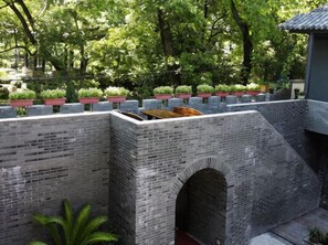 A brick wall with a series of planters and a small bridge.