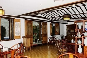 A traditional interior with wooden flooring, furniture, and a ceiling with exposed beams. - Shaoxing Dayue Xiaoyuan Culture Theme Hotel (Lu Xun's hometown Shenyuan Branch) (Shaoxing)