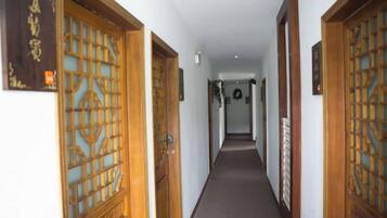 A corridor with traditional wooden doors and a carpeted floor.