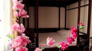 A traditional room with a bed, wooden furniture, and a window with curtains. - Shaoxing Dayue Xiaoyuan Culture Theme Hotel (Lu Xun's hometown Shenyuan Branch) (Shaoxing)
