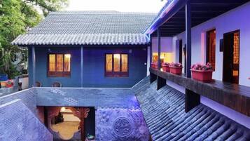 A traditional building with a tiled roof, a covered walkway, and a small courtyard.