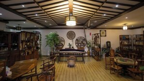 A traditional Japanese-style room with tatami flooring, wooden furniture, and a ceiling with exposed beams and hanging lanterns. - Shaoxing Dayue Xiaoyuan Culture Theme Hotel (Lu Xun's hometown Shenyuan Branch) (Shaoxing)