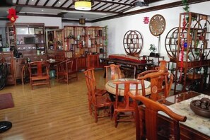 A traditional wooden interior with multiple seating arrangements and a bar area. - Shaoxing Dayue Xiaoyuan Culture Theme Hotel (Lu Xun's hometown Shenyuan Branch) (Shaoxing)