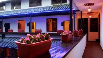 A traditional building with multiple rooms, each with a distinct entrance and a potted plant on the exterior.