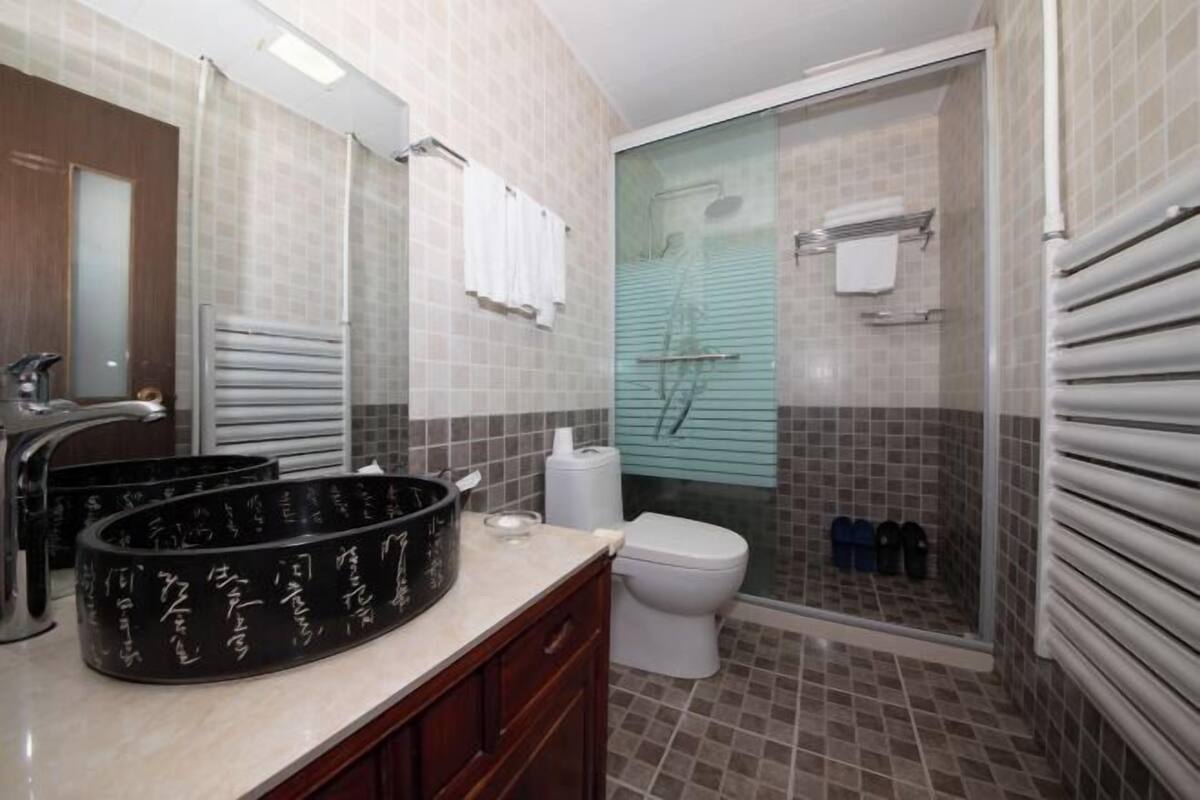 Ein Badezimmer mit Waschbecken, Spiegel, Toilette und einer Duschkabine.