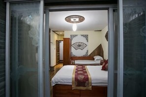 A room with a bed, a patterned wall, and a ceiling light fixture.