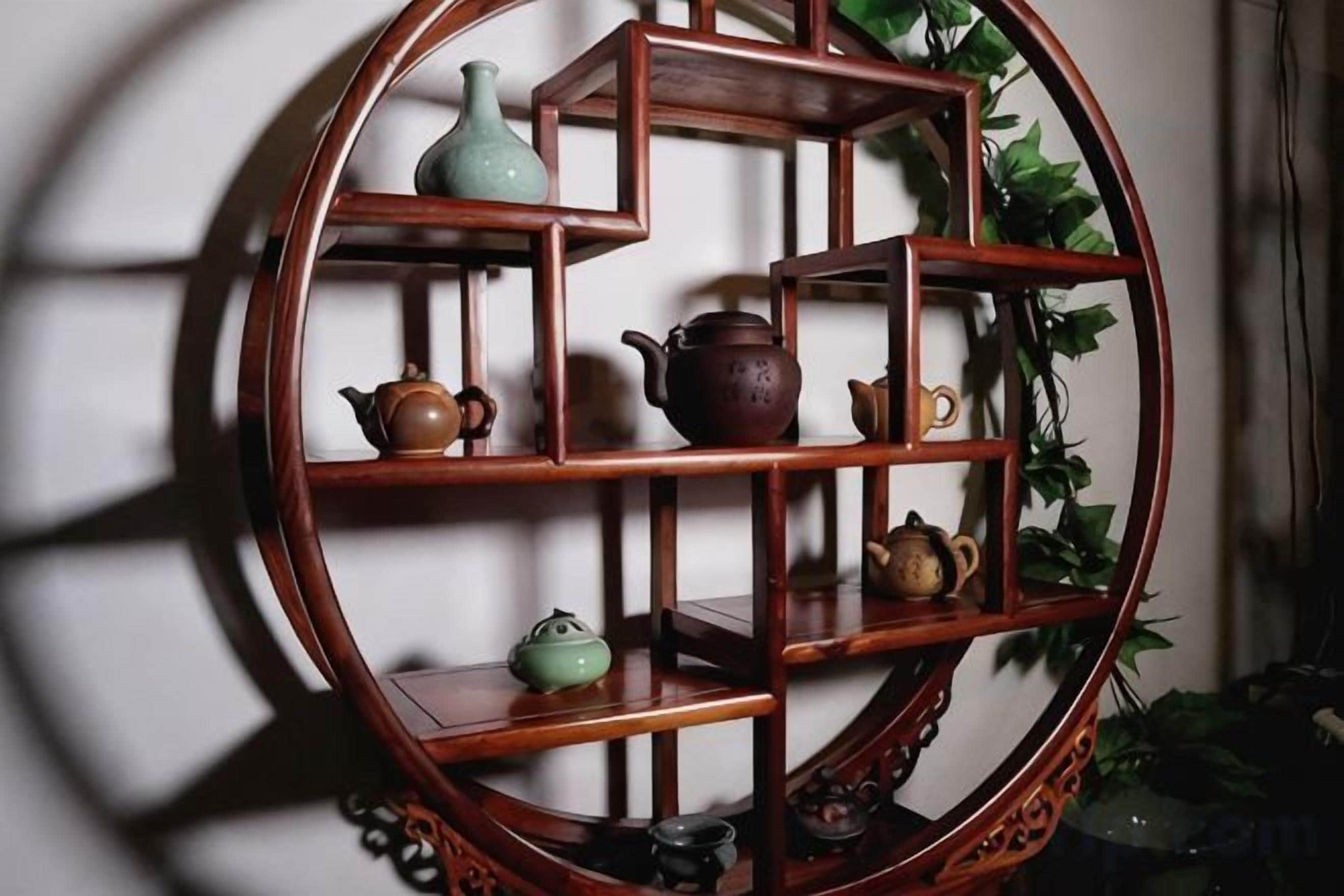 A round wooden shelf with multiple compartments, some containing pottery.
