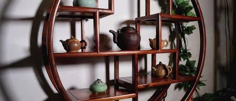 A round wooden shelf with multiple compartments, some containing pottery.