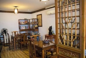 A traditional room with wooden furniture, a fan, and a bookshelf. - Shaoxing Dayue Xiaoyuan Culture Theme Hotel (Lu Xun's hometown Shenyuan Branch) (Shaoxing)