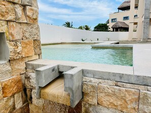 Una piscina al aire libre, sillones reclinables de piscina