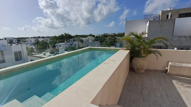 Ein Pool auf dem Dach mit freiem Blick auf die Skyline im Hintergrund.