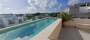 A rooftop pool with a clear view of the cityscape in the background. - Villas Tulum (Tulum)
