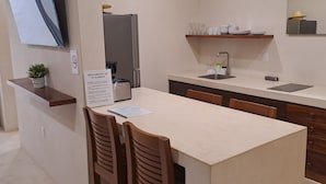 Eine moderne Küche mit Kühlschrank, Spüle und Holzstühlen.