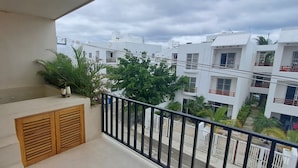 Ein Balkon mit Blick auf benachbarte Gebäude und eine kleine Gartenanlage.