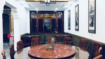 A dining area with a round table, chairs, and a chandelier.