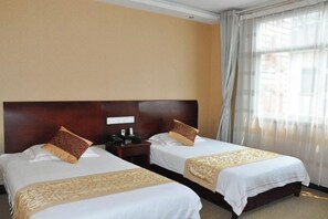 A hotel room with two beds, each with a wooden headboard, a nightstand, and a telephone. - Jiuhuashan Huimo Jiudu Hotel (Qingyang)