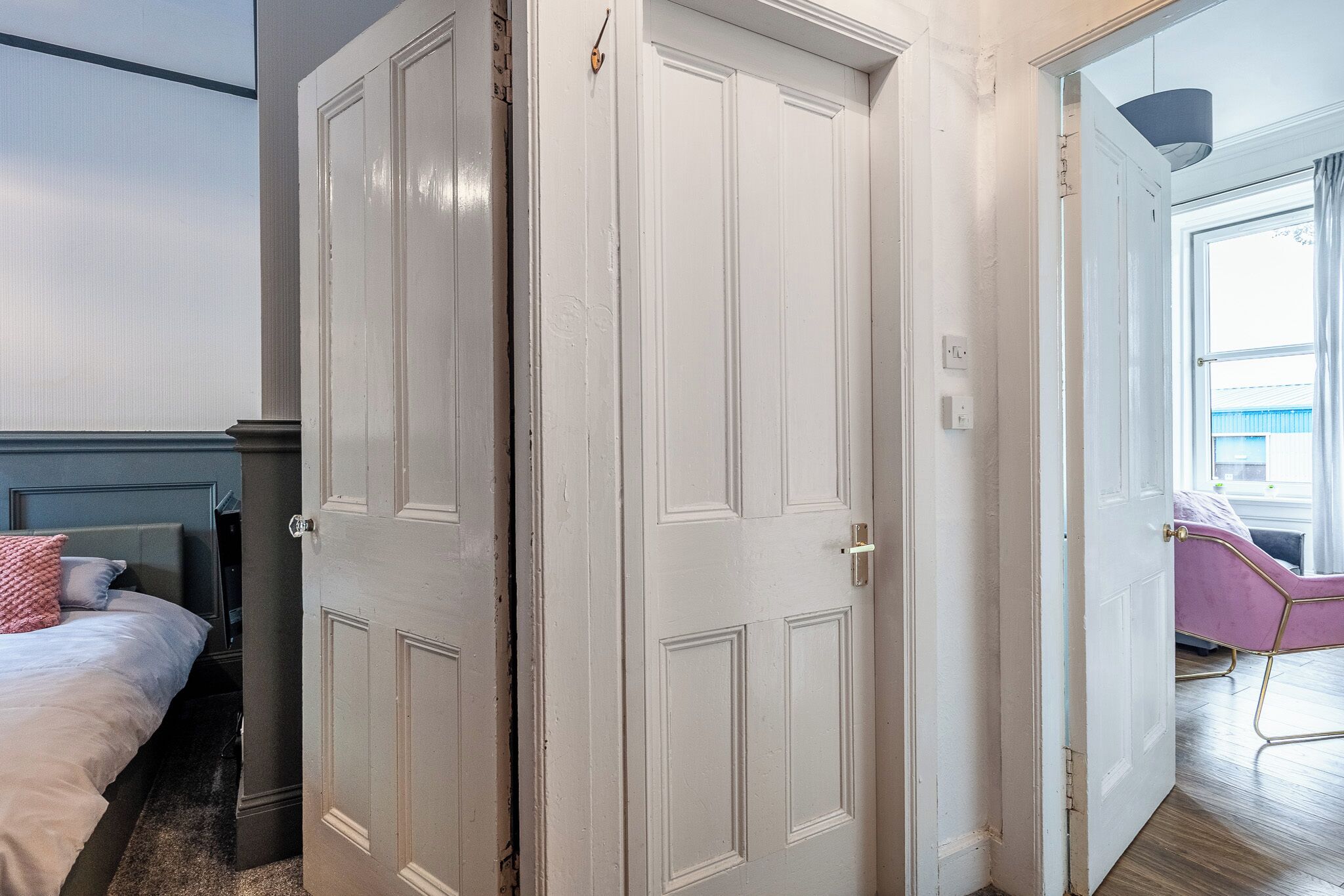Ein Schlafzimmer mit einem Bett, einem Kleiderschrank und einer Tür, die auf einen Balkon führt.