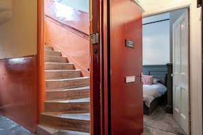 A staircase leading to a bedroom with a bed and a nightstand. - Our Wee Eden - Rothesay (Rothesay)