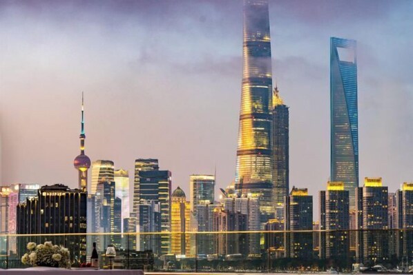 A city skyline with modern skyscrapers, including a distinctive tower with a spherical observation deck.