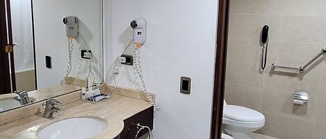 Un baño moderno con dos lavamanos, un espejo grande y un inodoro.