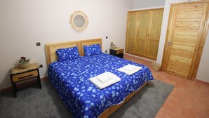 Une chambre à coucher avec un lit, une armoire en bois et une petite table de chevet avec une lampe.