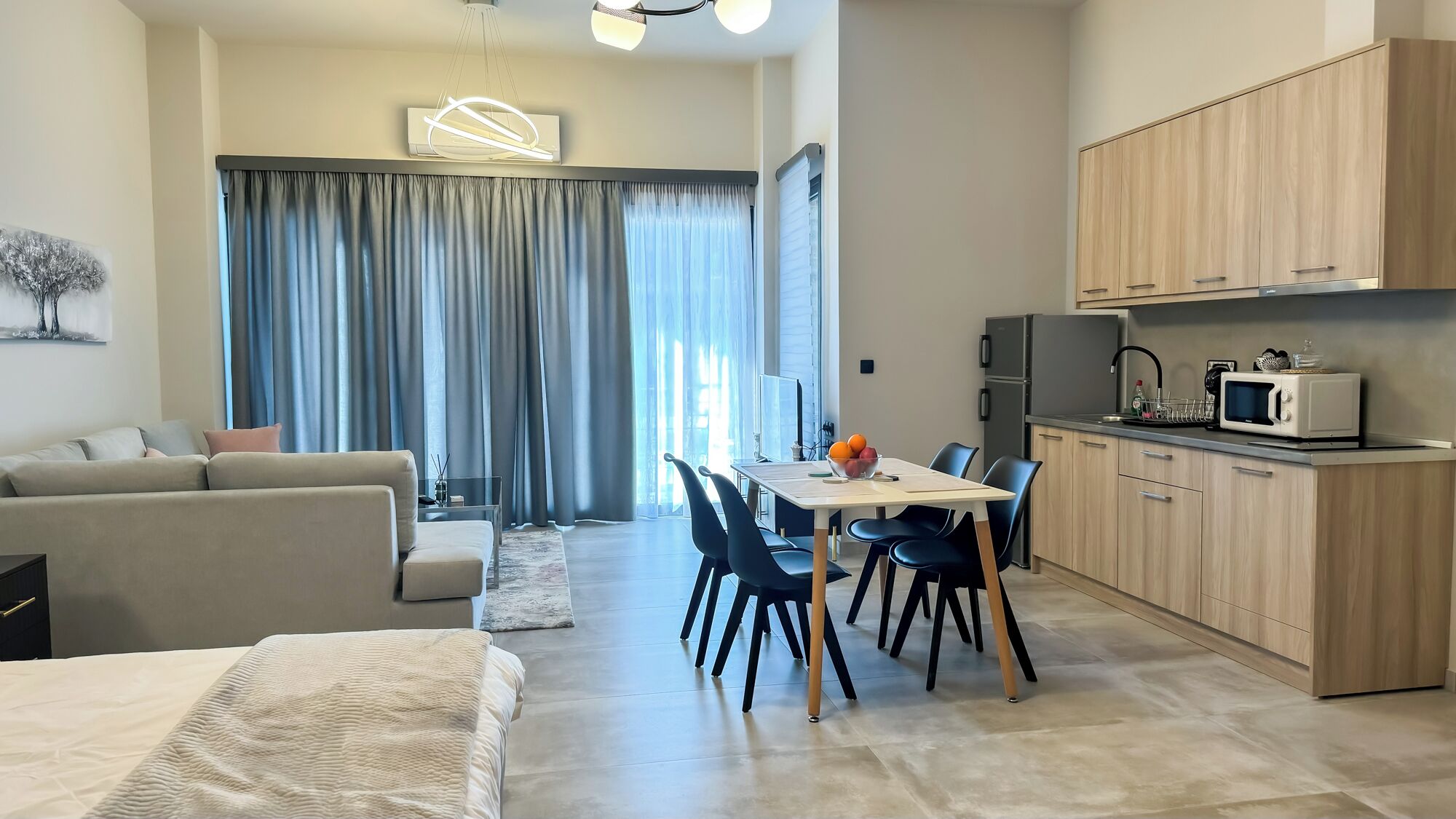 Un salon moderne avec un canapé et un coin repas comprenant des chaises et une table.
