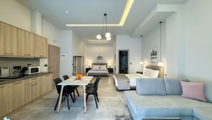 A modern apartment with a dining area, a living room with a sofa, and a bedroom with a bed.