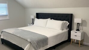 A bedroom with a bed, two bedside tables, a window with blinds, and a ceiling light. - Newly Remodeled 3-BR in heart of Marion (Marion)