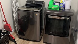 A laundry area with a washing machine, dryer, and cleaning supplies. - Newly Remodeled 3-BR in heart of Marion (Marion)