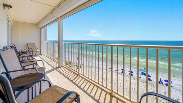 Een balkon met stoelen en uitzicht op het strand.