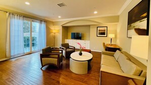 A spacious living area with a sofa, chairs, a round table, and a TV. -  Luxury home in Newport Beach city Near UCI (Newport Beach)