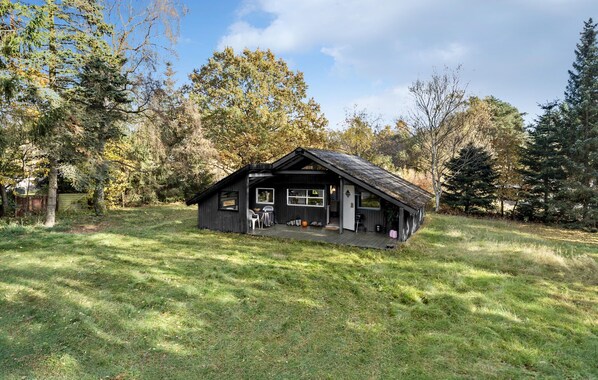 A small cabin with a porch, surrounded by trees and grass. - Stunning home in Rønde with WiFi (Rønde)