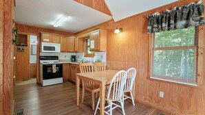 Un interior de madera con cocina, mesa y sillas.
