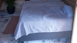Un dormitorio abrigado en el ático con una hamaca, una cama con almohadas, una planta en maceta y un cuadro en la pared.
