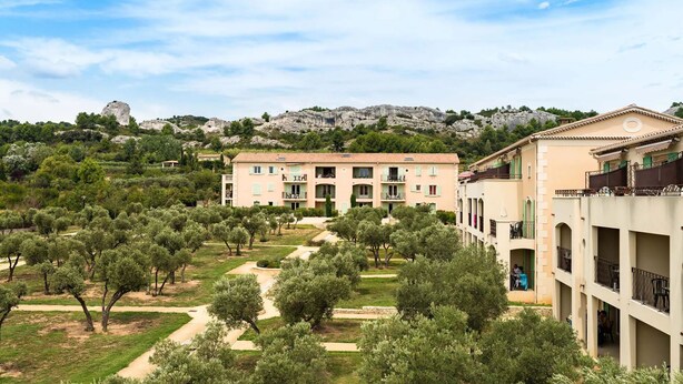 Un hôtel à étages, doté de chemins extérieurs et situé dans un cadre montagneux.