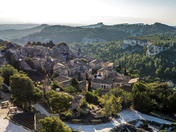 A historic town with stone buildings, a central square, and surrounding hills.